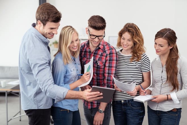 Three Quarter Shot of Five Young Office People Looking at the Tablet Screen Together with Happy Facial Expressions Inside the Office..jpeg