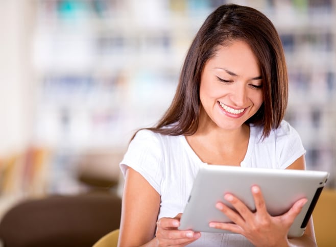 Woman reading at the library on an e-book reader.jpeg